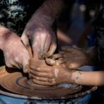 person making clay pot with clay